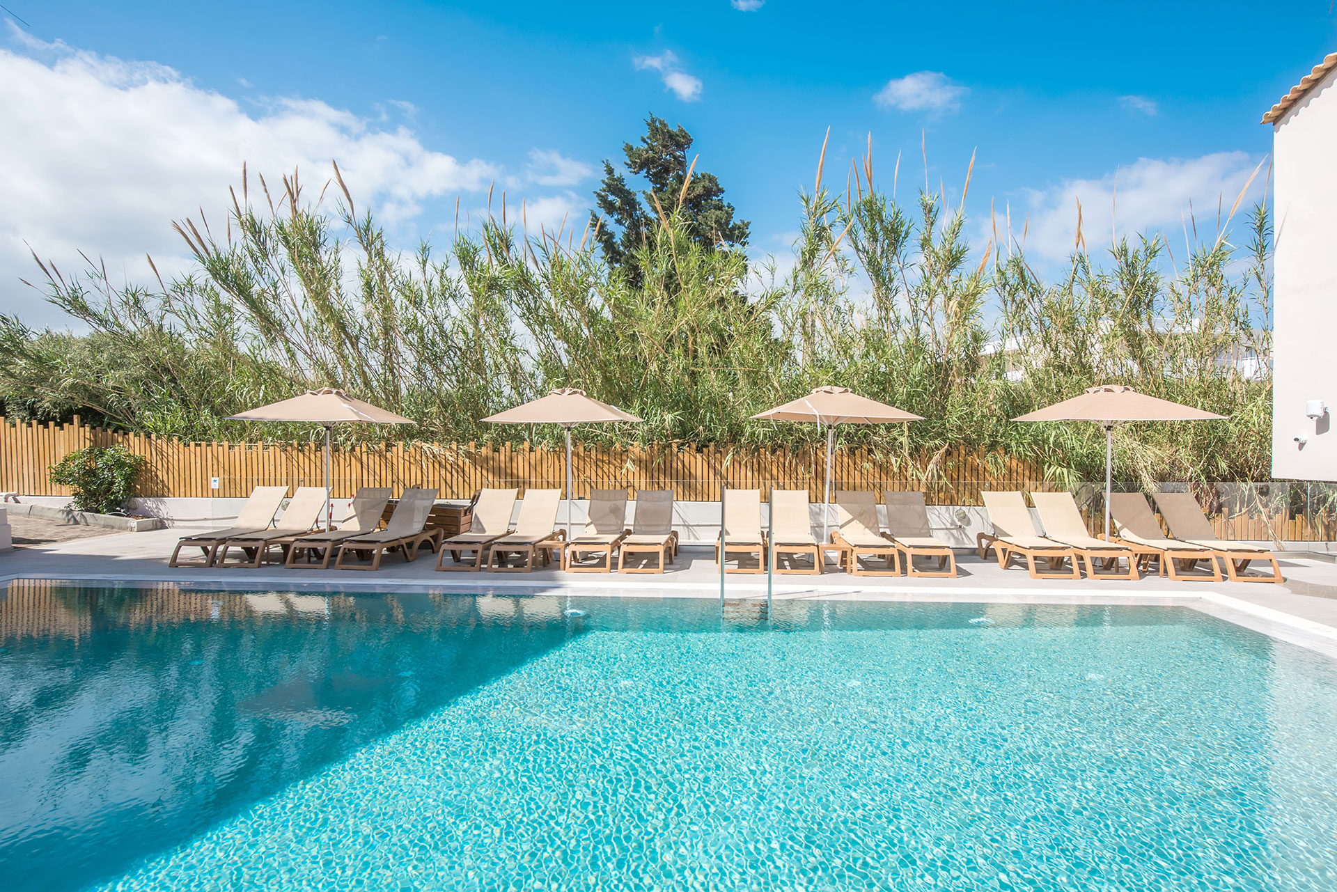 Gouves Park pool with four sets of sunbeds and umbrellas