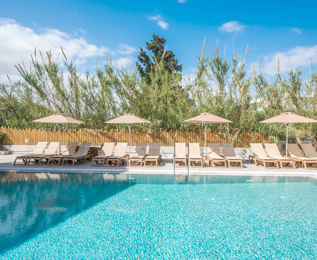 Gouves Park pool with four sets of sunbeds and umbrellas