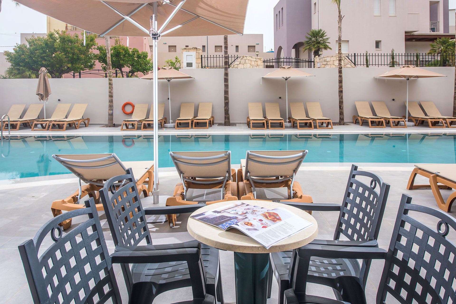 Gouves Park Family Suite Swim Up pool with a round table, chairs and sunbeds