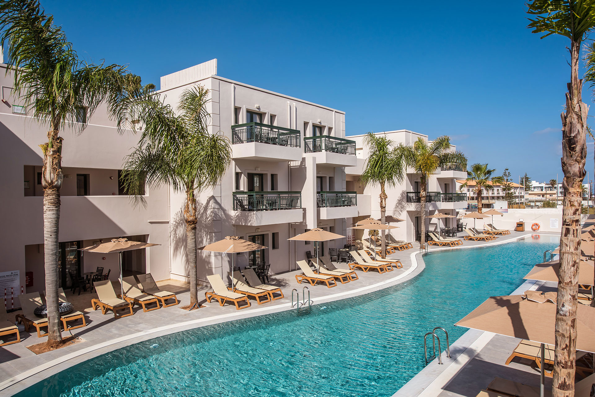 Gouves Park view of the pool with sunbeds, umbrellas and the hotel in the background