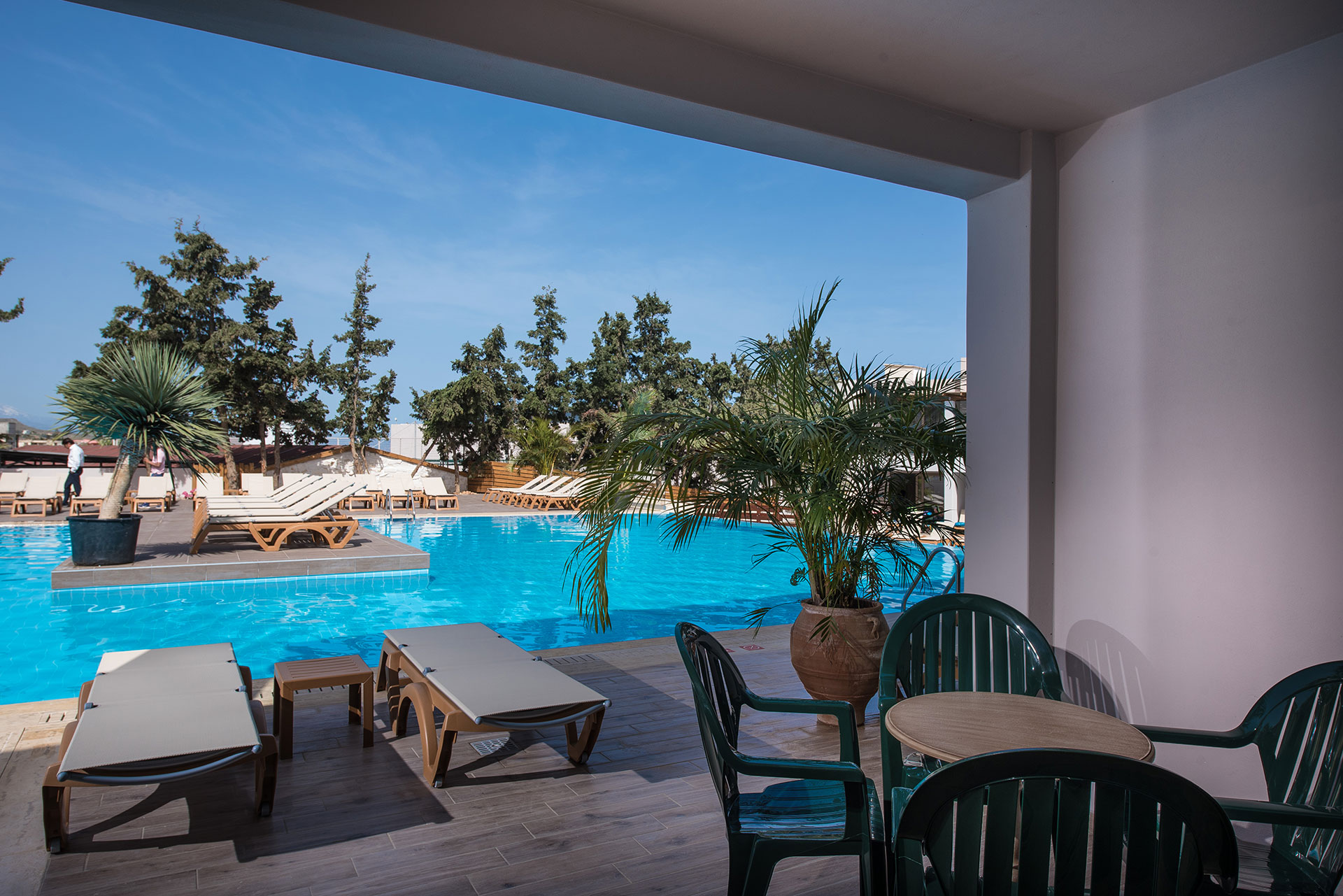 Gouves Park Family Suite Swim Up view from the balcony with a round table, four chairs and two sunbeds