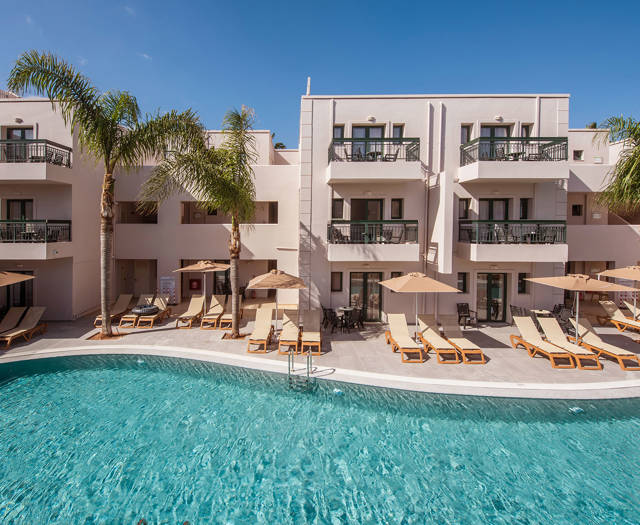 Gouves Park view of the pool with sunbeds, umbrellas and the straight view of the hotel in the background