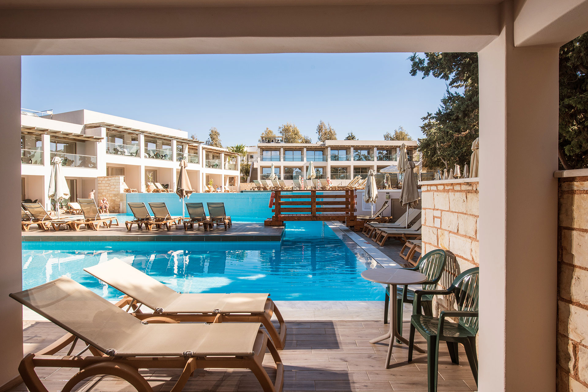 Gouves Park Family Suite Swim Up terrace with two sunbeds, a round table with two chairs and access to the pool