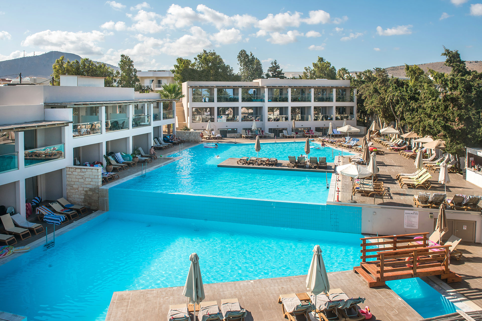 Gouves Park large pool of two levels with sunbeds and umbrellas in the side