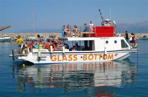 A tour boat in the middle of the sea, full of people, with the sign Glass Bottom