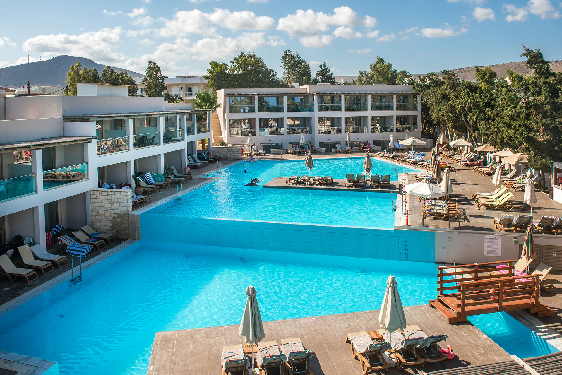 Gouves Park large pool of two levels with sunbeds and umbrellas in the side