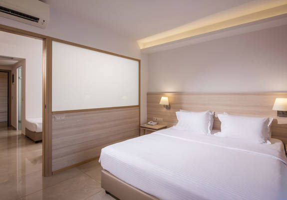 Gouves Park Family Suite bedroom with one double bed, two beside tables and amenities