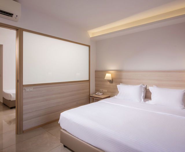 Gouves Park Family Suite bedroom with one double bed, two beside tables and amenities